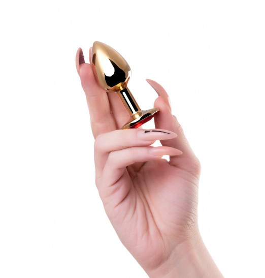 Золотистая гладкая коническая анальная пробка с красным кристаллом - 7 см.